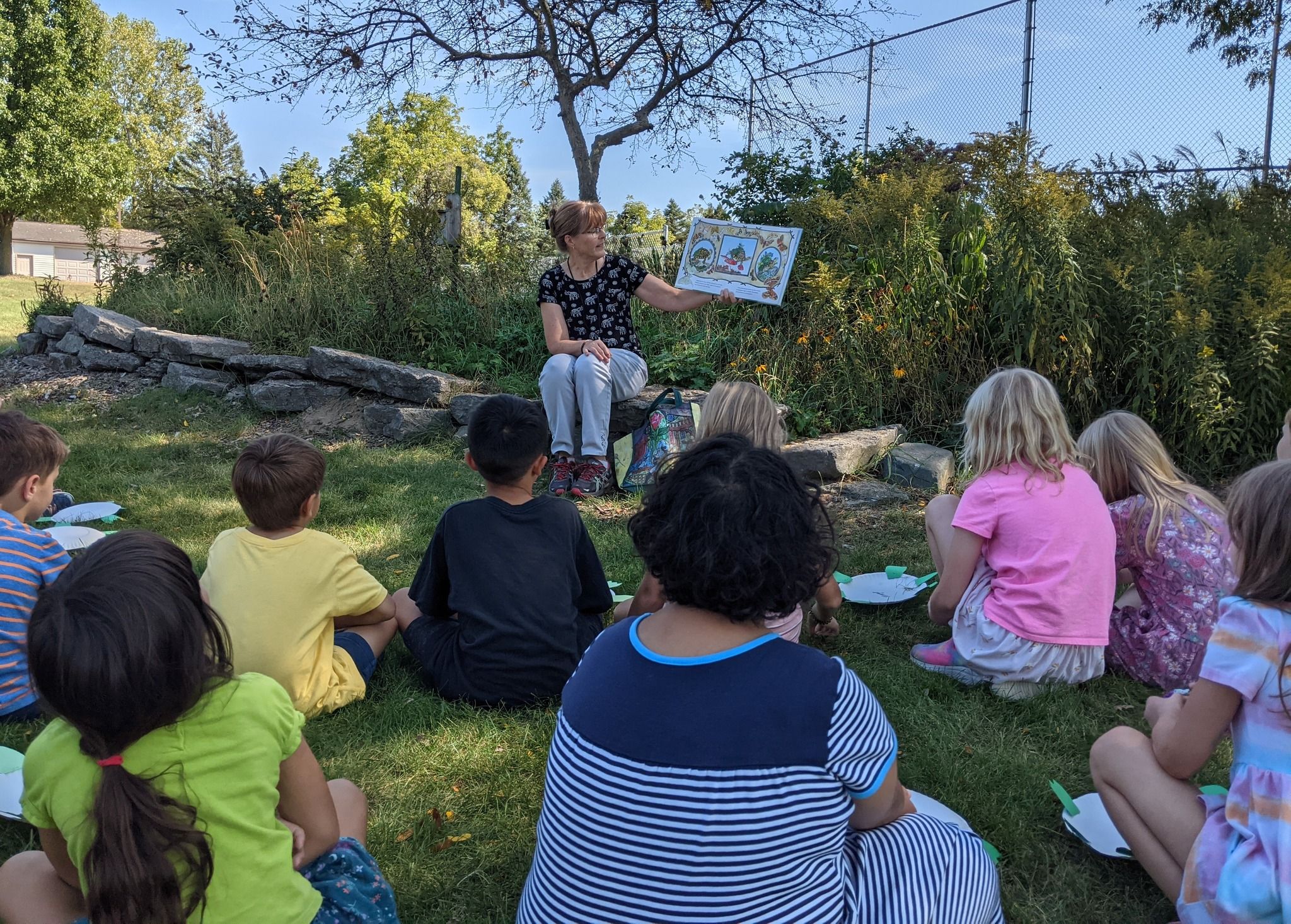 teacher reading to students outdoors
